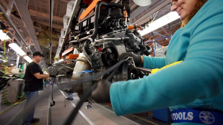A worker installing a timing belt on a Chrysler minivan motor at the Windsor assembly plant in Ontario