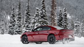 A Dodge Charger GT AWD kicks up snow from the rear of the car.