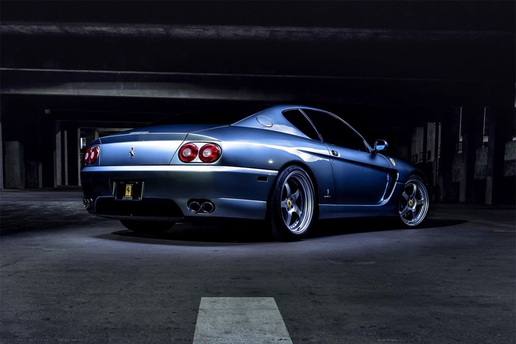 Ferrari 456 blue rear 3/4 shot under bright light in underground parking garage for cars and bids listing, doug demuros website