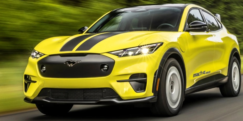 A yellow Ford Mustang Mach-E Rally small electric SUV is driving. 