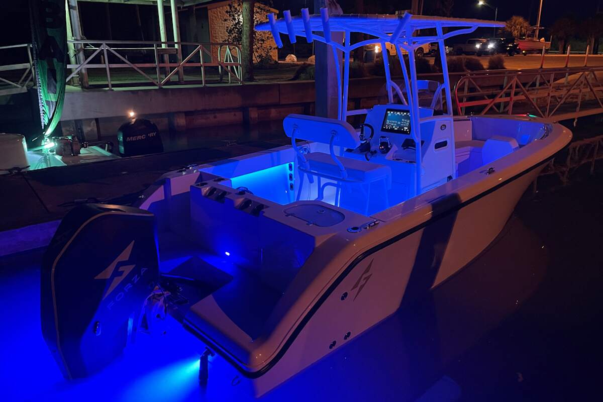 A Forza X1 F-22 electric boat illuminated at night while docked in a marina