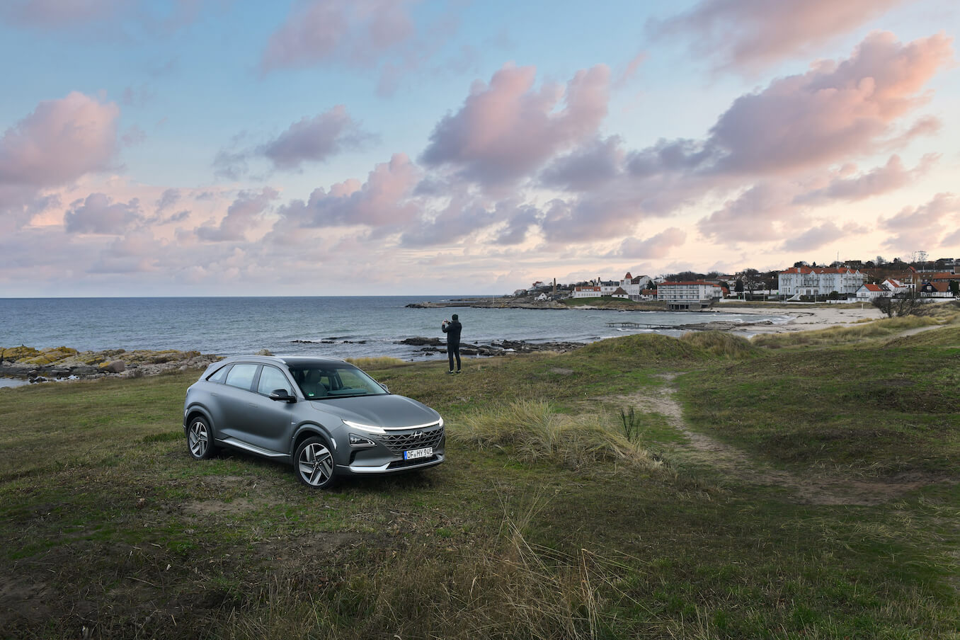 A gray Hyundai Nexo parked along the coastline at the beach. The Hyundai Nexo's hydrogen fuel cell makes it a unique model.