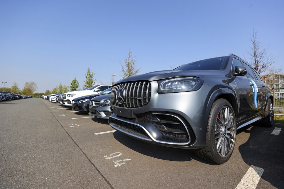 A Mercedes-Benz AG GLE SUV and other new and used automobiles in a customer collection parking lot at a Daimler AG showroom. The Mercedes-Benz GLE price makes it a better choice than the Maserati Levante.
