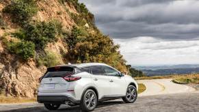 Nissan's most reliable SUV, the 2023 Nissan Murano, pictured in white parked ahead of a cliff.
