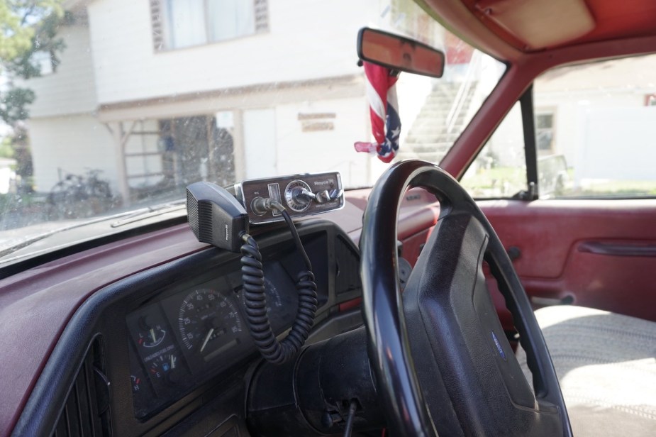 Aftermarket CB radio on the dashboard of an old truck.