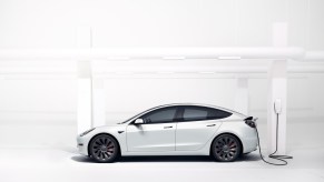 A white Tesla Model 3 charging. One of the most common Tesla Model 3 complaints has a hilariously obvious solution.