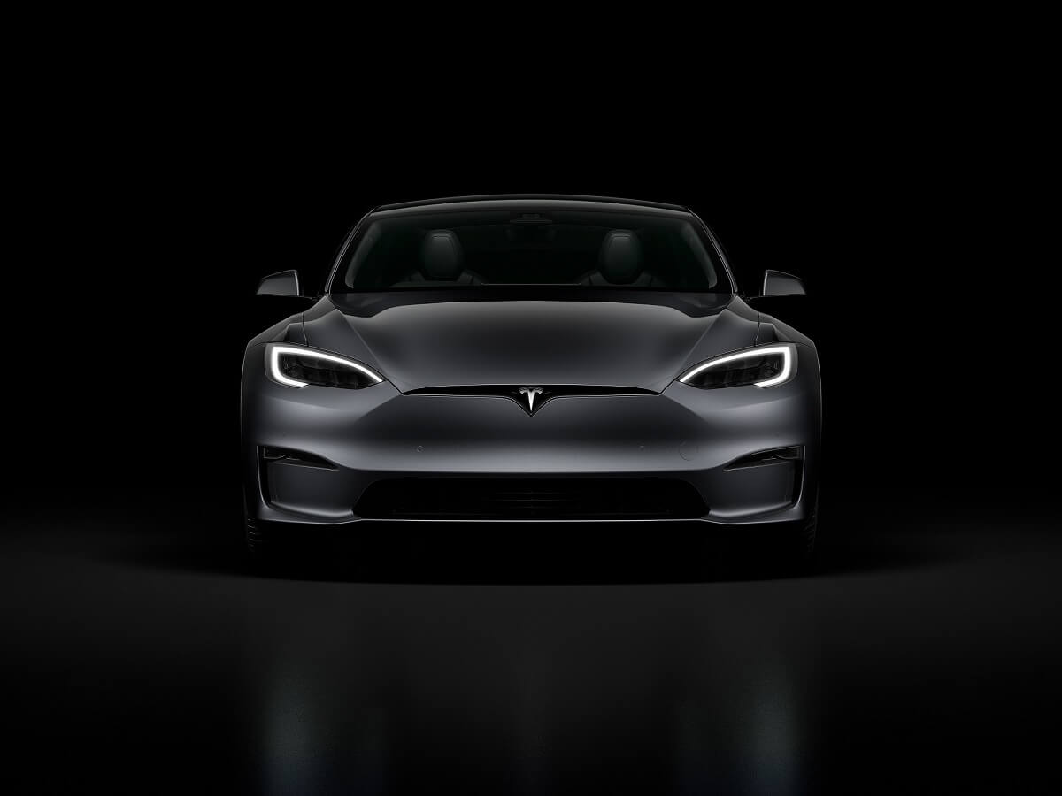 A gray Tesla Model S sits in the dark.