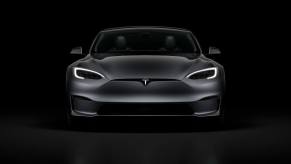 A gray Tesla Model S sits in the dark.