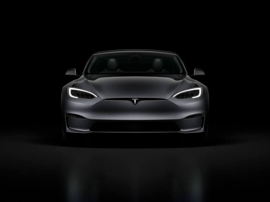 A gray Tesla Model S sits in the dark.