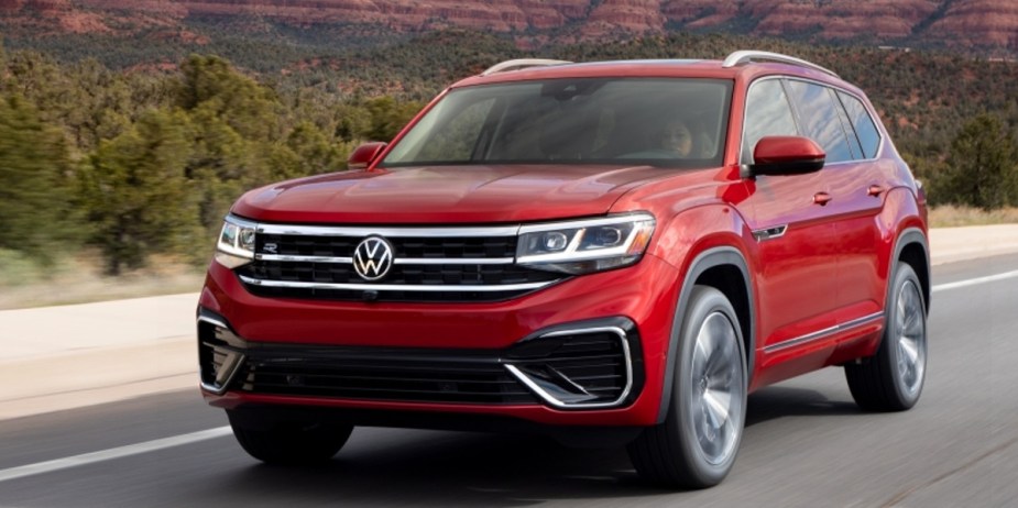 A red Volkswagen Atlas is driving on the road. 