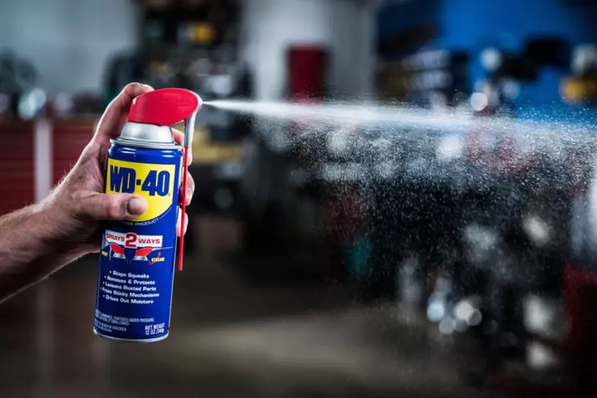WD-40 spray lubricant with hand spraying out the product