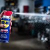 WD-40 spray lubricant with hand spraying out the product