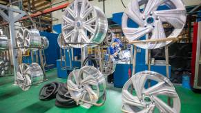 An energy vehicle workshop in Yuncheng, China, where workers are working on an order of aluminum alloy car wheels