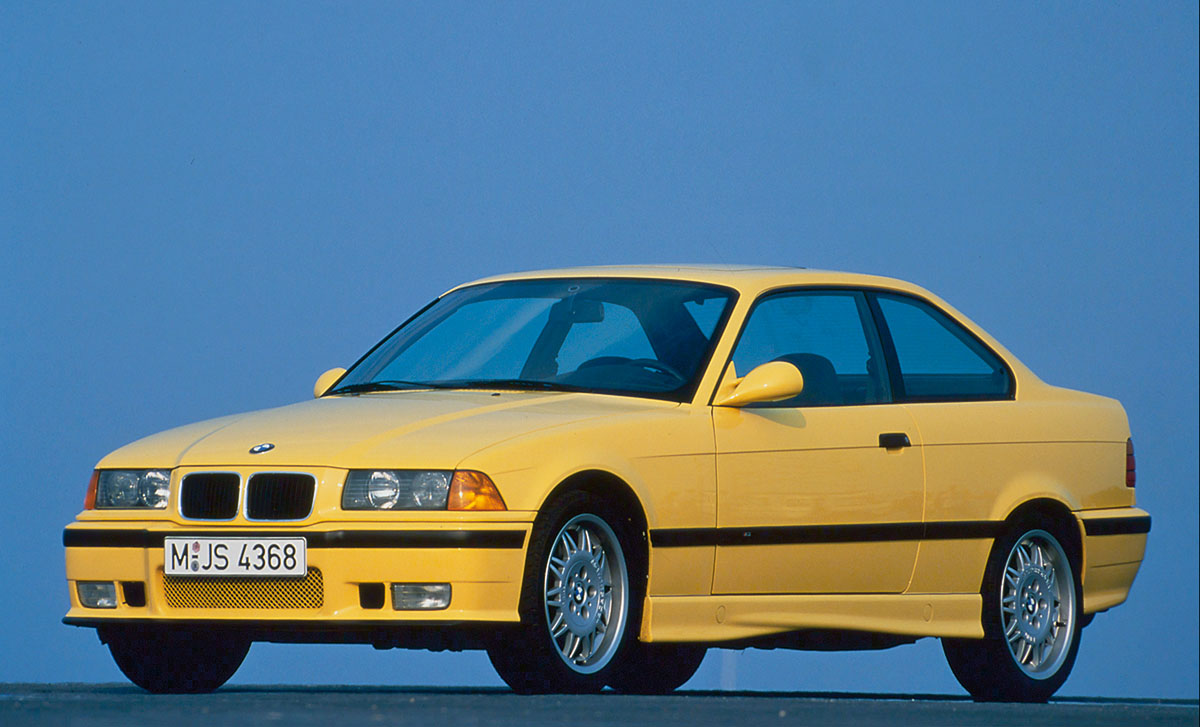 Front 3/4 of a bright yellow 1992 BMW 325i Coupe E36, one of the best cheap sports cars for sale on the used market