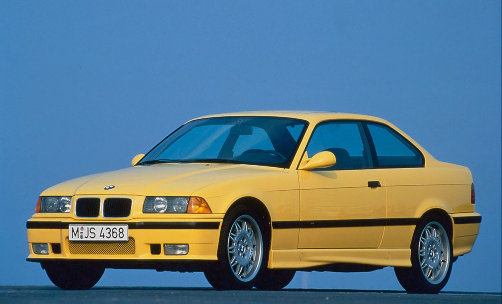 Front 3/4 of a bright yellow 1992 BMW 325i Coupe E36, one of the best cheap sports cars for sale on the used market