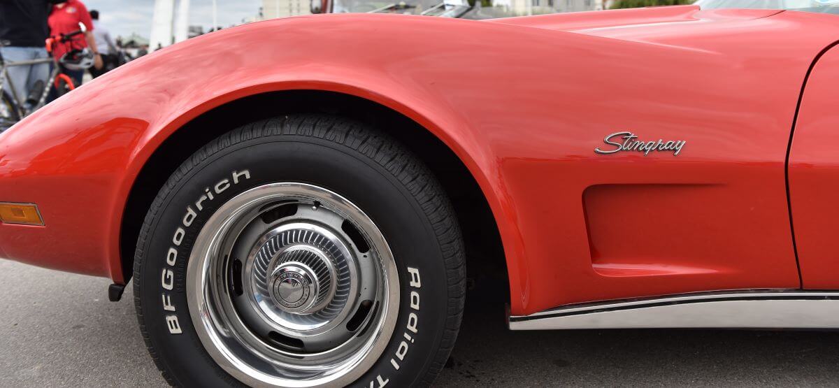Polished chrome wheels on a Goodrich tire on a red Chevy Corvette Stingray on display