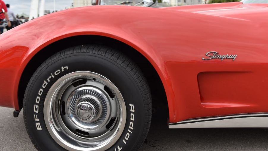 Polished chrome wheels on a Goodrich tire on a red Chevy Corvette Stingray on display