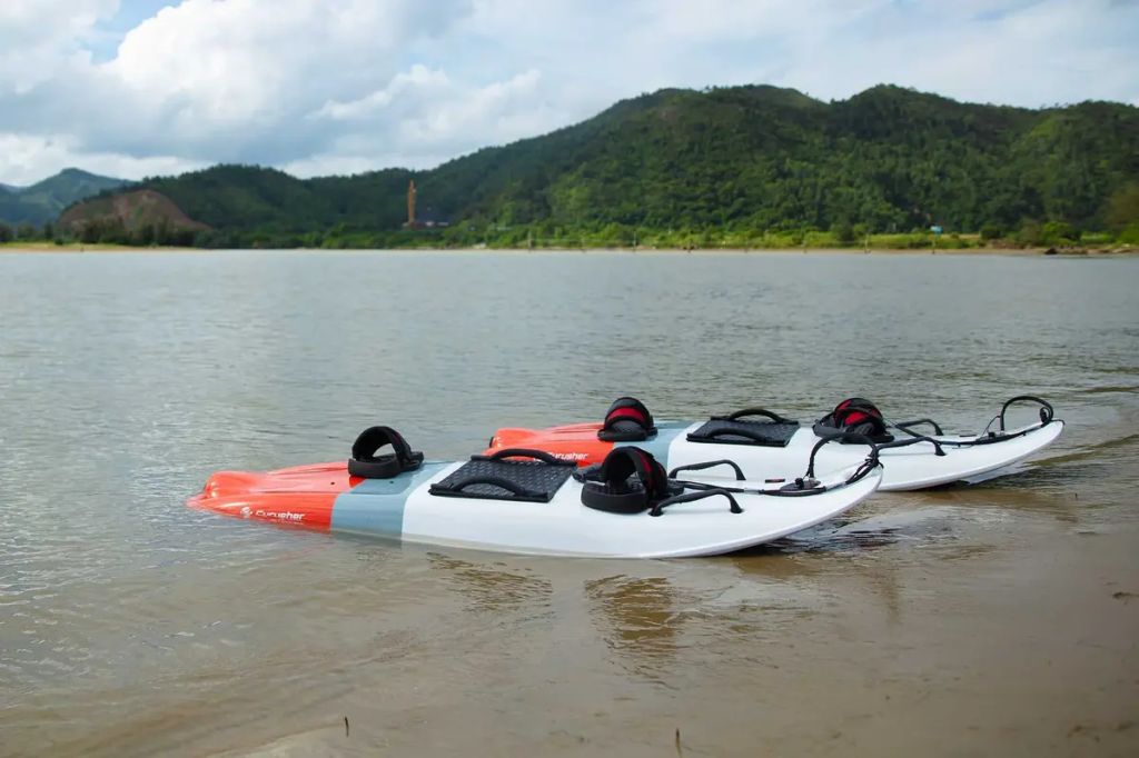 Two Cyrusher Thunder 54-inch electric surfboards sitting on lake