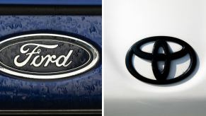 The automaker logos of the Ford (L) and Toyota (R) car companies