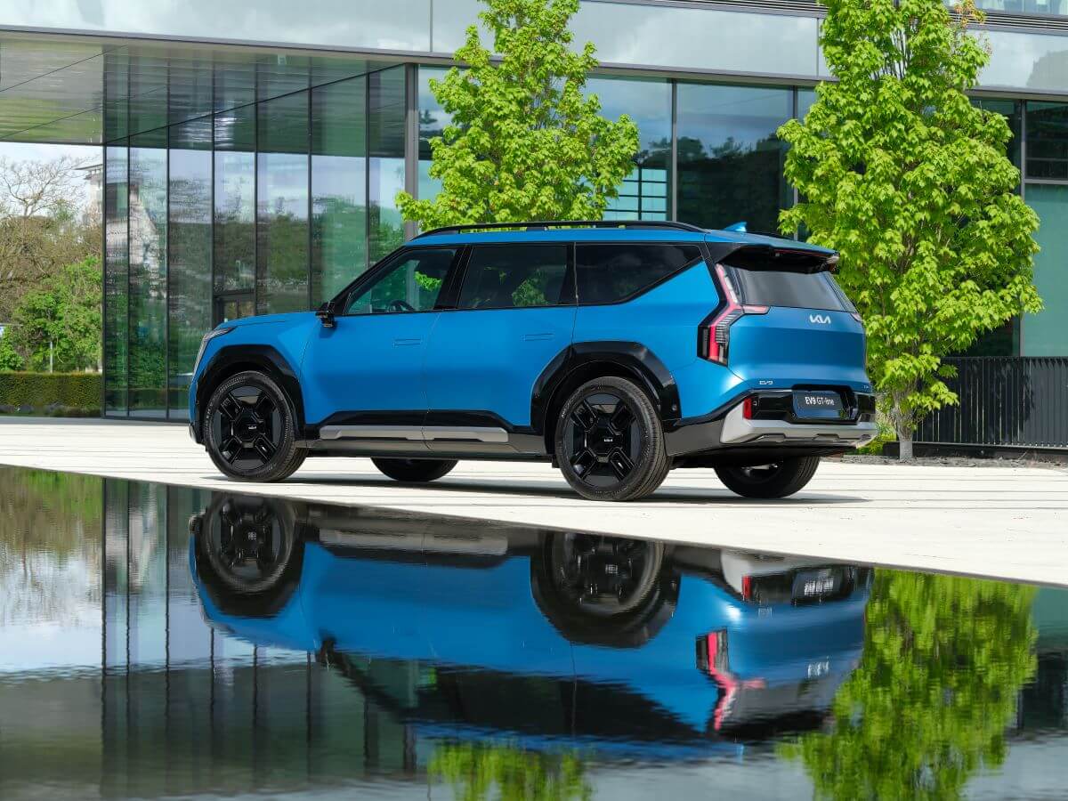 The all-electric 2024 Kia EV9 midsize SUV model parked on a plaza with a reflection off the water