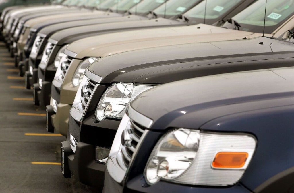 A row of new cars lined up on a dealership lot