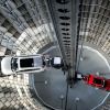 A machine organizes Volkswagen cars in a circular parking garage.
