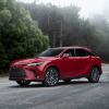 A 2024 Lexus RX 350h midsize luxury SUV model parked on a forest road covered in fog