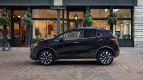 A side profile shot of a 2022 Buick Encore subcompact SUV model parked on a cobblestone walkway