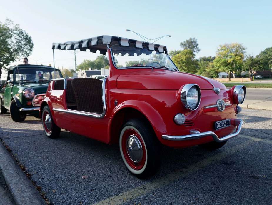 A red antique Fiat "Jolly" convertible beach car at a car show.