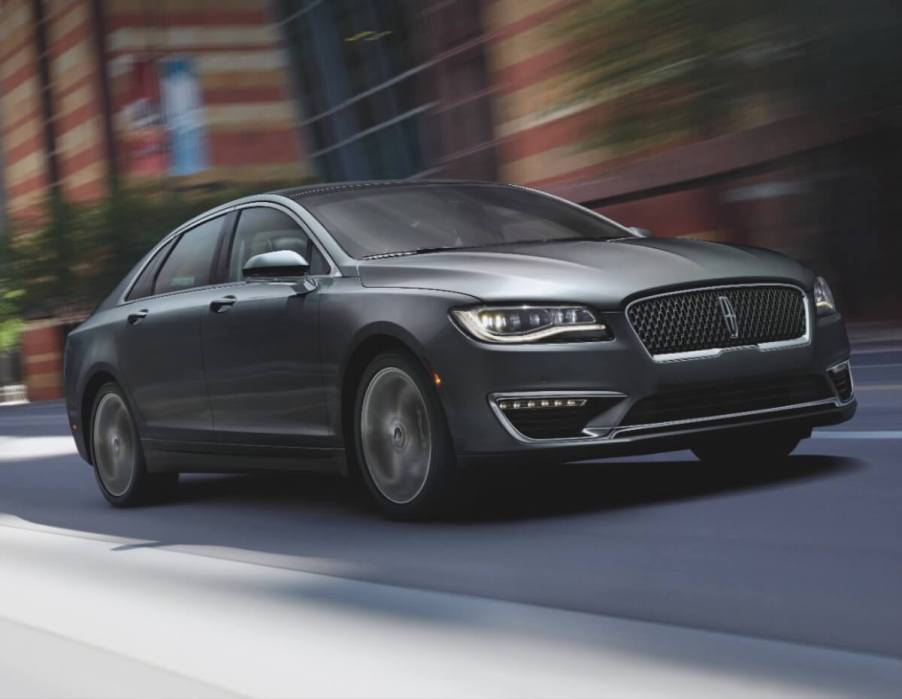 A gray 2018 Lincoln MKZ luxury car cruises down a city street.