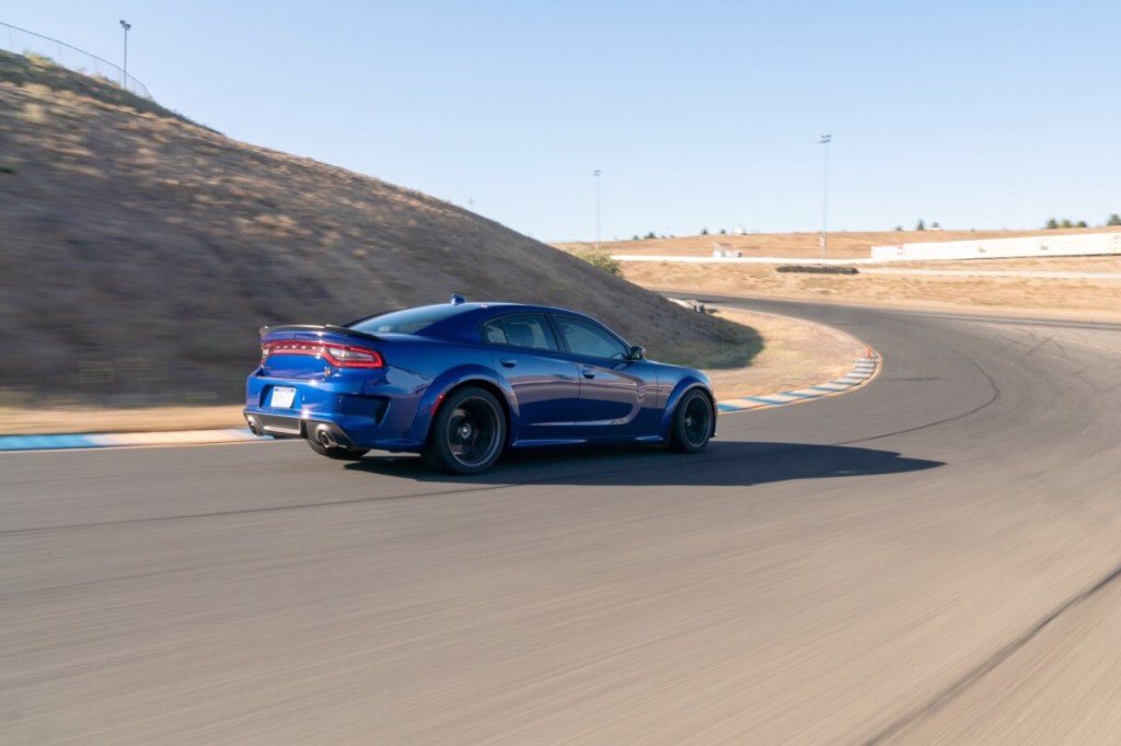 A blue 2020 Dodge Charger R/T Scat Pack Widebody drives around a corner on a track.