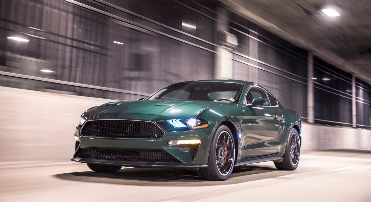 A Dark Highland Green 2020 Ford Mustang Bullitt drives through a tunnel.