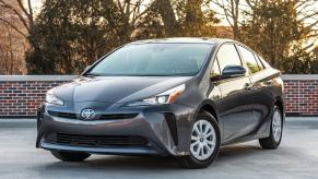 A used hybrid 2020 Toyota Prius L Eco shows off its hatchback car styling and front fascia.