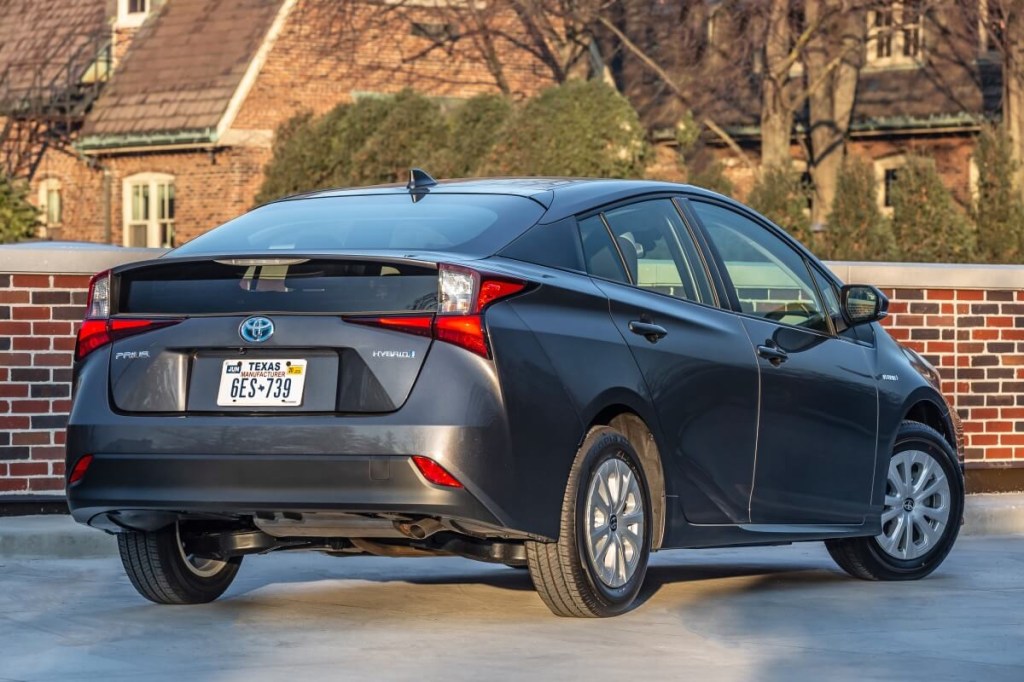 A used hybrid 2020 Toyota Prius L Eco shows off its four-door car application and rear-end styling.