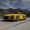 A yellow Audi R8 driving down an open road.