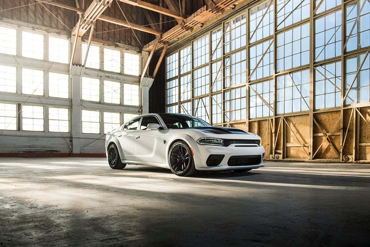 A white 2022 Dodge Charger Widebody American car parks in a warehouse.