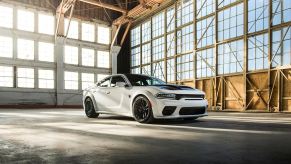 A white 2022 Dodge Charger Widebody American car parks in a warehouse.