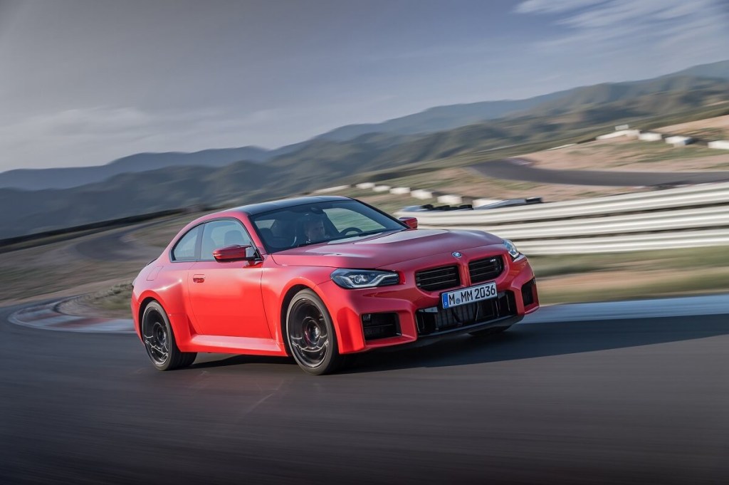A new BMW M2 drives around a corner.