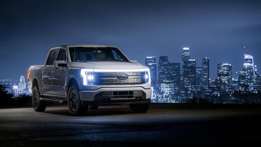 The 2023 Ford F-150 Lightning parked near a city at night