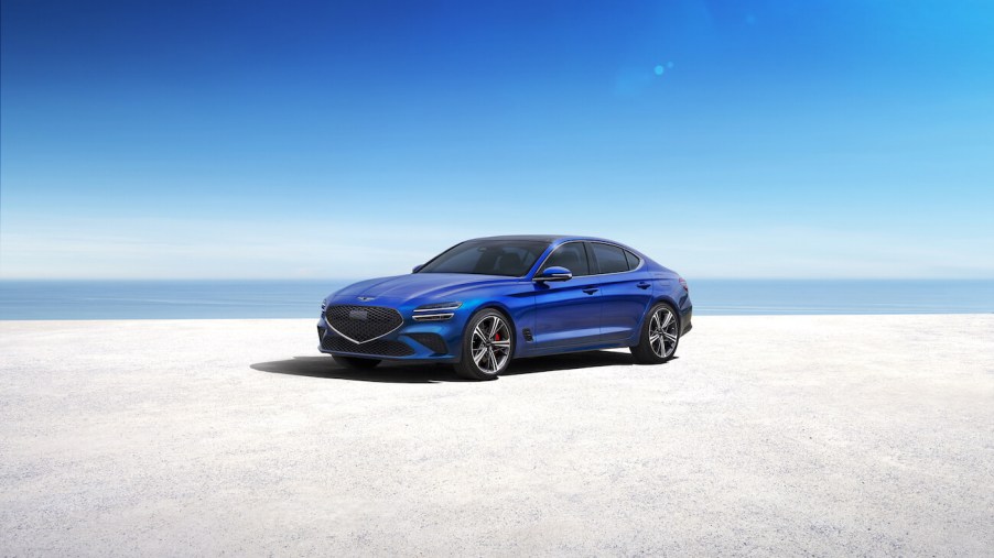 2023 Genesis G70 in blue parked on the shore. The G70 sales need to go up ASAP.