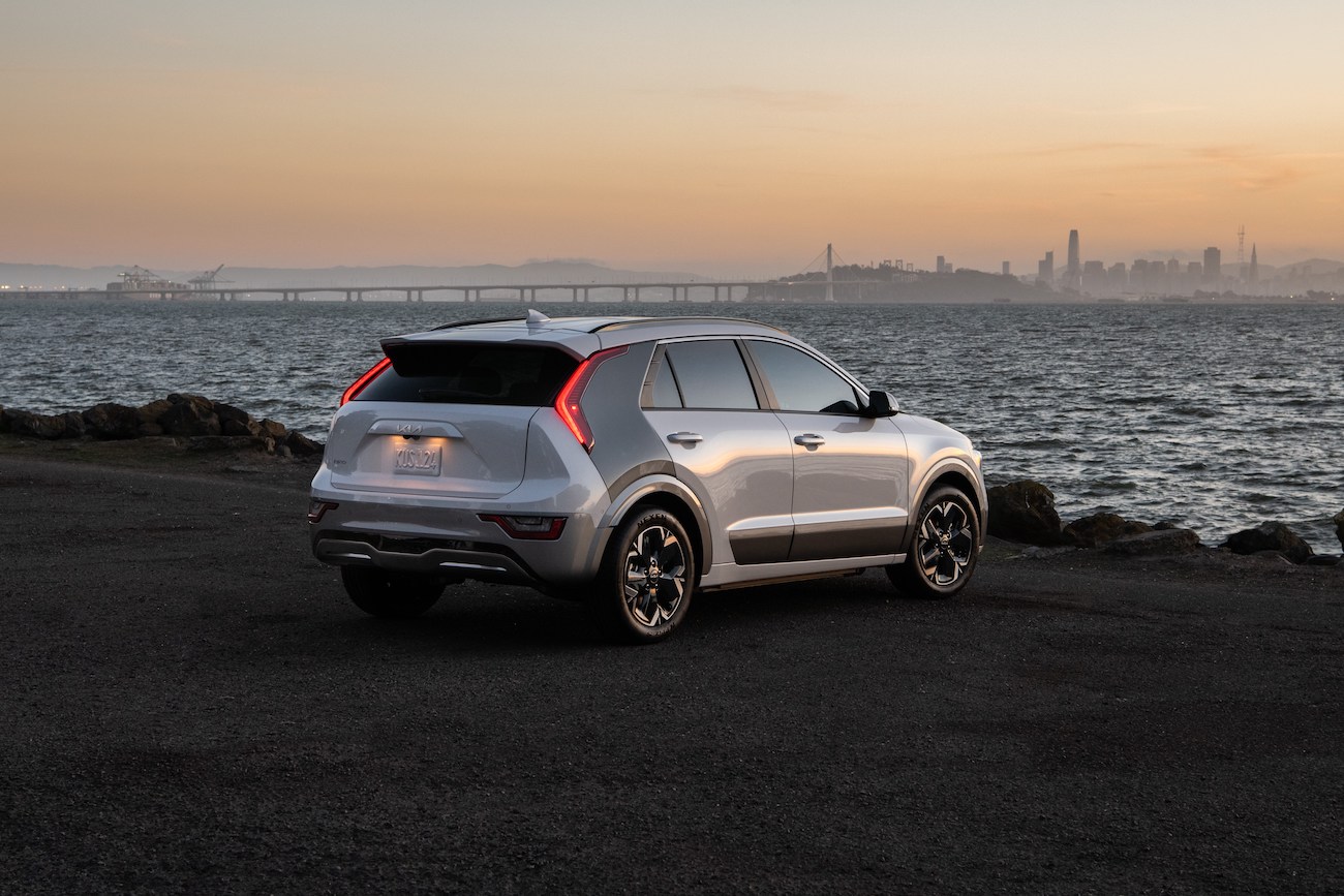 The 2023 Kia Niro EV parked on a cliff in front of water. The Kia Niro EV competes with the Hyundai Kona Electric.