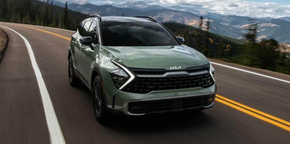 A green 2023 small SUV is driving on the road. 