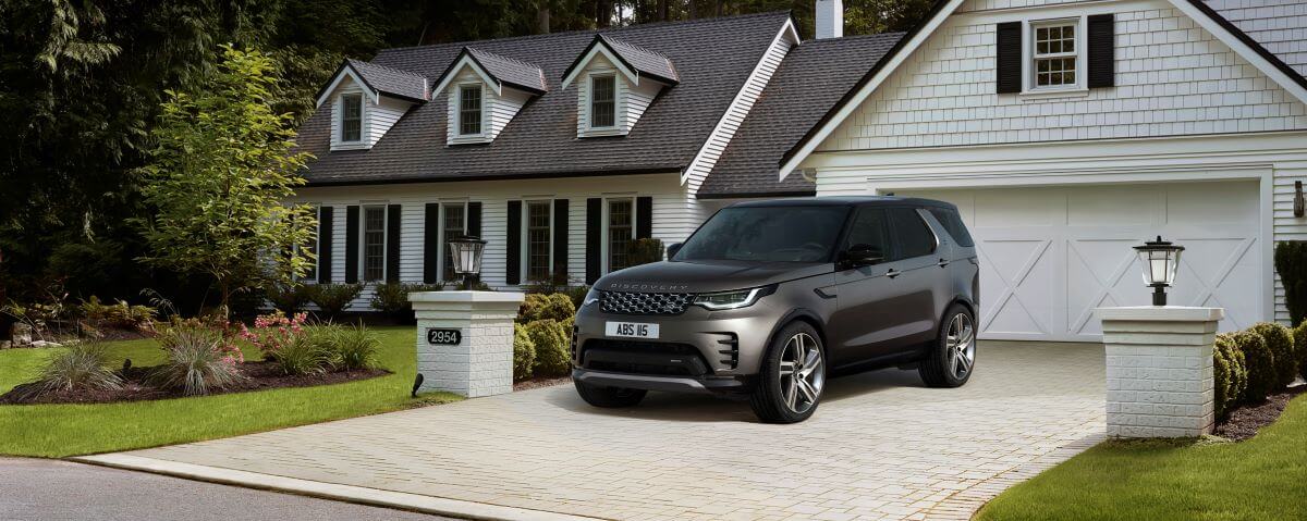 A 2023 Land Rover Discovery Metropolitan Edition midsize luxury SUV parked on a cobblestone home driveway