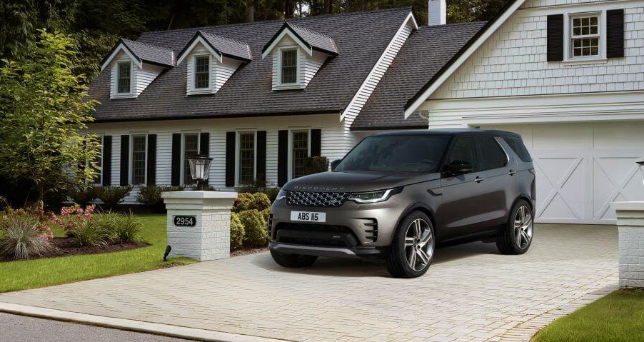 A 2023 Land Rover Discovery Metropolitan Edition midsize luxury SUV parked on a cobblestone home driveway