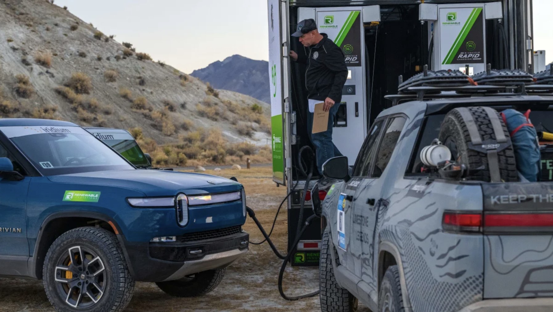 Rivian R1T electric pickup trucks charging battery packs at a DC Fast charger. 