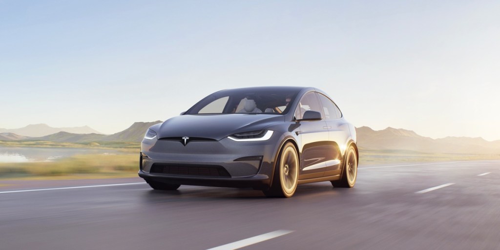 A gray 2023 Tesla Model X is driving on the road.