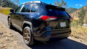 A rear corner view of the 2023 Toyota RAV4 Woodland Edition on a mountain road
