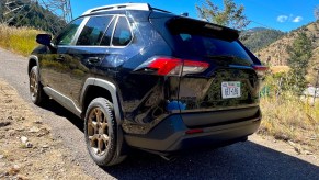 A rear corner view of the 2023 Toyota RAV4 Woodland Edition on a mountain road
