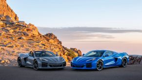 Two 2024 Chevy C8 Corvette E-Ray models parked in front of a desert hill. 2024 C8 Corvette changes are fascinating.