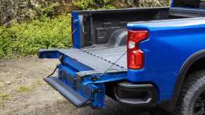 The pickup bed of a blue Chevrolet Silverado 1500 ZR2 parked in the woods.